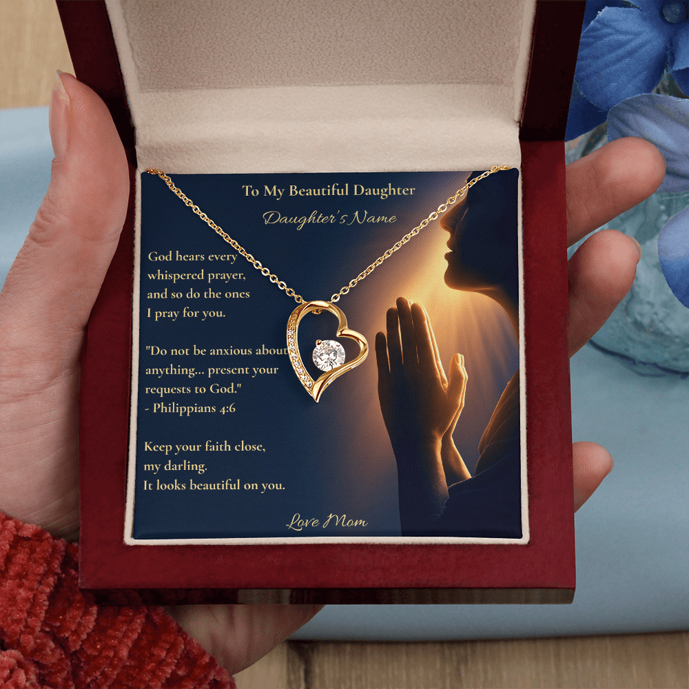 Hand holding a gold heart necklace and personalized daughter card with Philippians 4:6